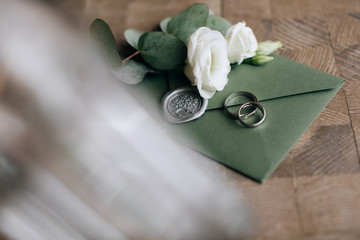 Wedding invitation letter for guests in green envelope and white roses