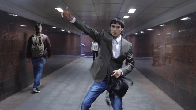 Attractive man with a briefcase dancing in subway