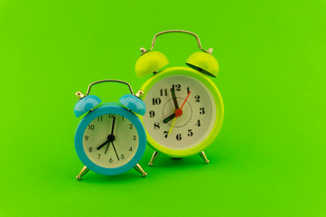 Twin bell analog alarm clock over green background