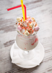 Baby milk dessert in a glass on a gray wooden background. Restaurant serving