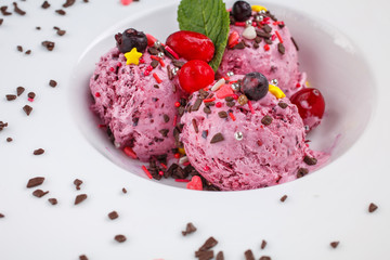 Fruit dessert decorated with mint, chocolate and berries in a white plate. The view . Close up.