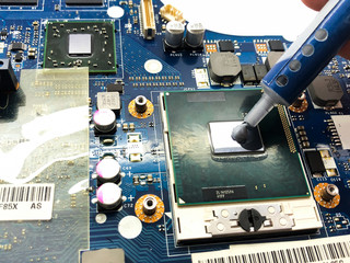 Thermal grease and motherboard isolated on white background. Replacing thermal grease on a laptop.