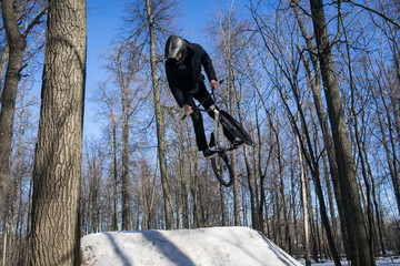 mtb rider does a 360 trick on dirt jumping in winter. Cyclist doing a springboard stunt in winter
