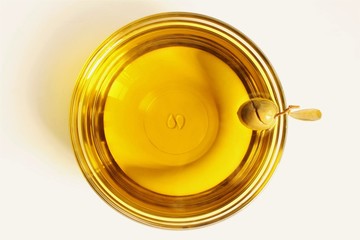 Bowl of olive oil with broken green olive beside the bowl. photo isolate on white top view 