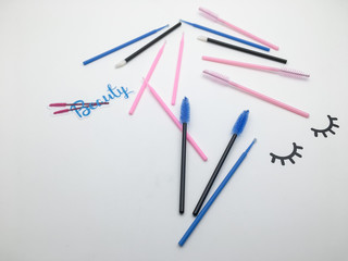 Top view on eyelash extension tools. Flatlay of multi-colored brushes for combing cilia.