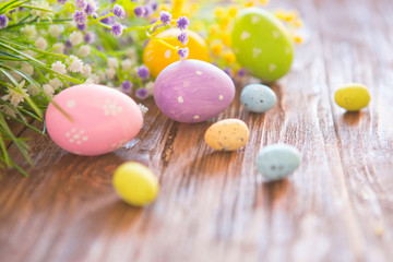 Obraz na płótnie Canvas Easter eggs and branch with flowers on rustic wooden background.