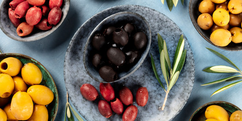 Olives flat lay panorama. Black, green and brown olives, shot from the top
