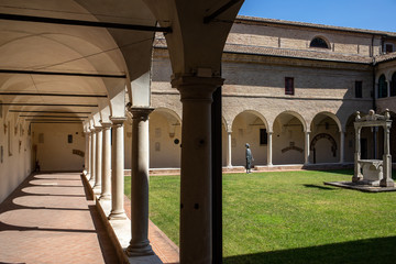 Courtyard with decorated columns, arches and green lawn of old Franciscan friars cloister near the...