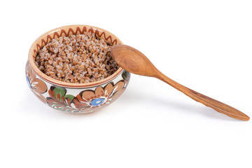 Buckwheat porridge in the clay bowl with wooden spoon
