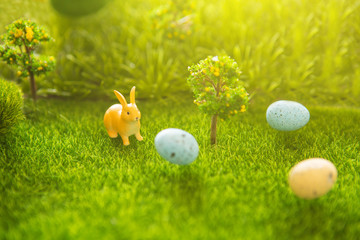Easter decorate with rabbit toy and Easter eggs on grass field background