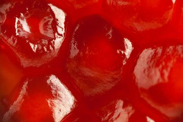 Super macro of ripe pomegranate. Fresh sweet garnet grains, close up.