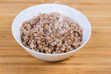 Freshly prepared buckwheat porridge in white bowl close-up