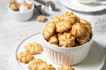 Lemon cookies with poppy seeds in a white ceramic bowl on the gray kitchen table. Shortbread. Space for text