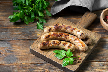 Fried sausages on a wooden Board on a brown wooden table. Rustic style