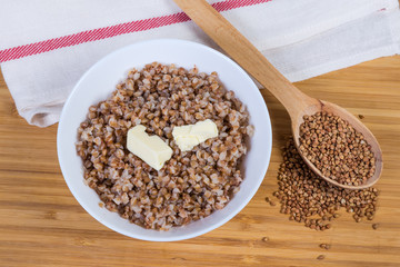 Top view of buckwheat porridge with butter, uncooked buckwheat groat
