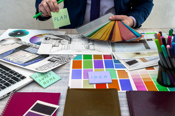 Designer develops a sketch of interior illustration with color scheme of material on a table, office workplace.  Desktop of an architect and interior designer with samples
