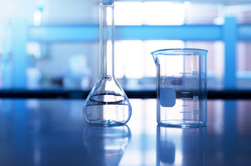 beaker and volumetric flask on chemistry science laboratory table background