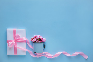 Gift box wrapped in white paper with pink ribbon