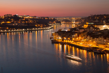Naklejka premium Atardecer en la desembocadura del río Douro, con el puente de la Arrábida al fondo que separa las localidades de Oporto y Vila Nova de Gaia (Portugal).