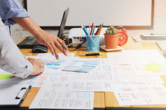 UX or UI designers designing on their smartphone application layout prototype project. - Powered by Adobe