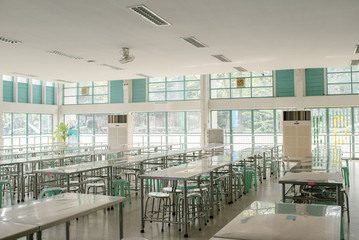 Clean school cafeteria with many empty seats and tables in Bangkok Thailand.