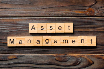 Asset management word written on wood block. Asset management text on wooden table for your desing, Top view concept