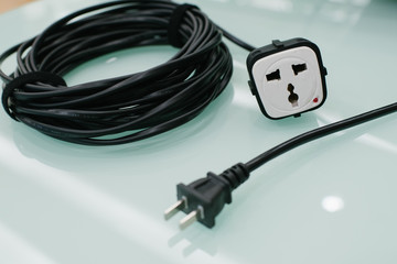 Extension cable in front of green glass background