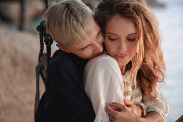 Young beautiful lesbian couple sitting on a swing by the tropical sea, beauty and fashion, vacation...