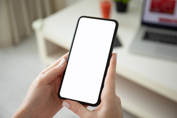 female hands holding phone with isolated screen and laptop