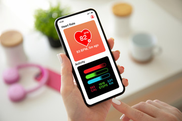 female hands holding phone with app heart and activity