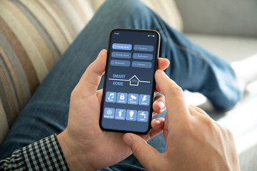 male hands holding phone with app smart home on screen