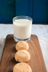 Butter cookies and a glass of milk on a wooden board