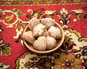 Russian gingerbread cookies in a wooden plate on a home carpet
