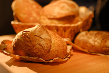 Assortment of baked bread on wooden table background. Bread background, top view of white, black and rye loaves. Healthy food. 