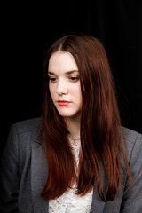 Portrait of successful business woman in 
a grey jacket on black background