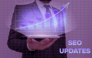 Writing note showing Seo Updates. Business concept for new information or design in search engine...