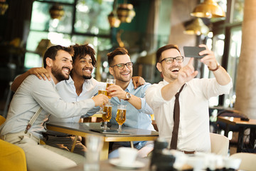 a group of different business people who sit in a pub and drink beer after work.