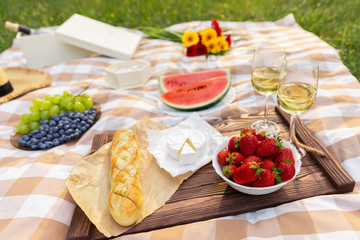 Romantic picnic in nature. The beauty of the setting sun, fresh fruits and wine.