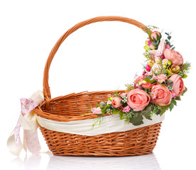 Fototapeta na wymiar Brown wicker basket. Decor on one side of the basket handle with pink flowers and a small pink ceramic hare. Made for Easter.