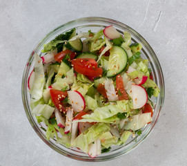 Healthy food. Vegetarian salad of radish, tomatoes, cucumbers, salad leaves with sesame seeds.