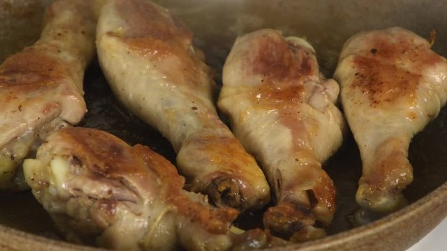 Shaking the fried chicken legs in a skillet and cover with a lid