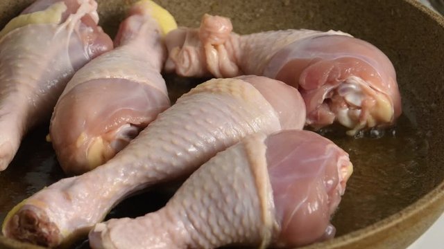 Raw Chicken Legs Close-up Frying In a Pan On The Stove