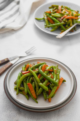Vegan food. Cooked green string beans and carrots. Healthy salad of green beans and carrots close up.