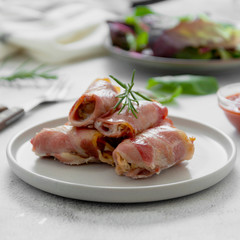 Delicious pigs in blankets, meat wrapped in bacon, homemade cooked meat bites. Bright food photo.