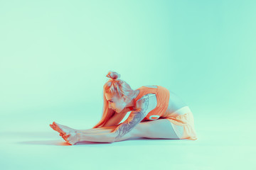 Athletic young woman doing yoga exercise. Neon lights