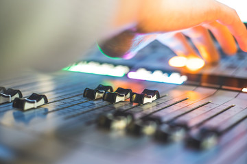 Sound recording studio mixer desk: sound engineer is operating a professional music production
