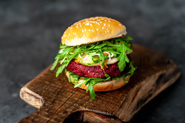 veggie burger with beets, chickpeas, pear, arugula, cucumber on a cutting board on a stone background