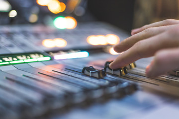 Sound recording studio mixer desk: sound engineer is operating a professional music production