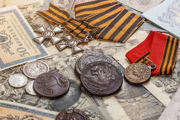 Gold and silver coins of the Russian Empire19 - 20 century in the background kopyur.Five rubles Nicholas II.Concept Russian antiques.Saint George cross of Imperial Russia.Antikvariat.