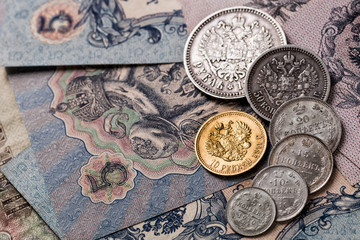 Gold and silver coins of the Russian Empire19 - 20 century in the background kopyur.Five rubles...